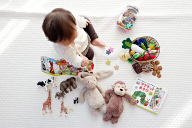 Petit enfant assis avec différents jouets