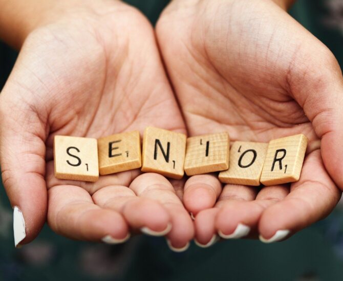 Senior dice on person's palm